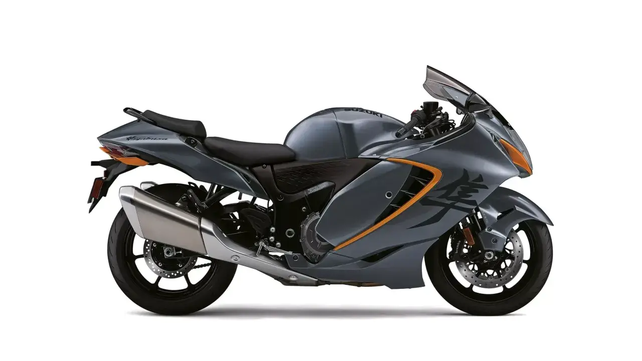 Motocicleta Suzuki Hayabusa gris con detalles naranjas, lista para la velocidad. Su diseño aerodinámico sugiere potencia, como si tuviera un turbo oculto.