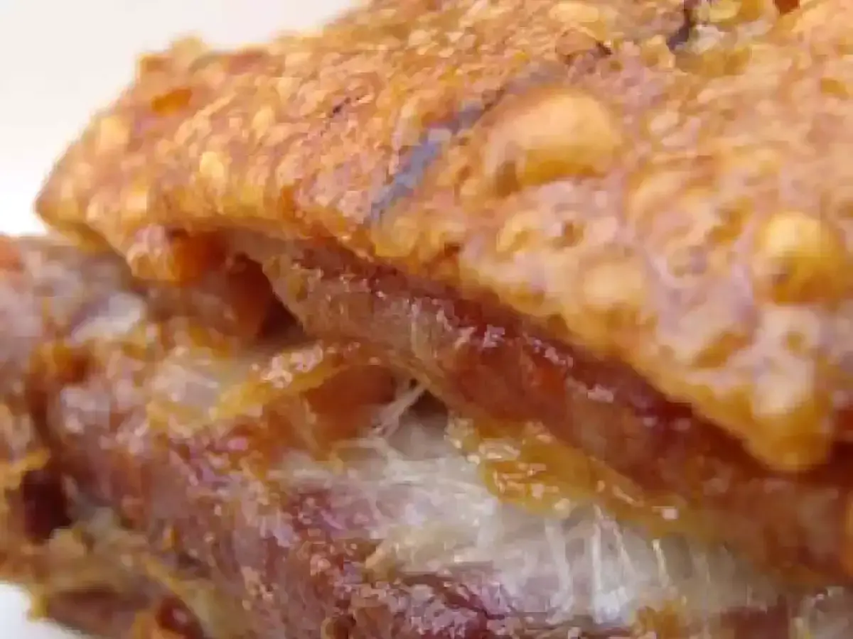 Gros plan sur un délicieux lard rôti au four, la couenne croustillante et dorée, la chair tendre et juteuse. Un vrai régal !