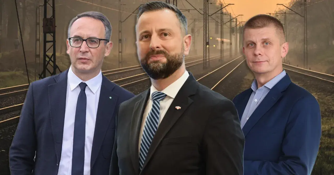 Trzech mężczyzn w garniturach na tle torów kolejowych. Jeden z nich, z brodą, wygląda jak prezes PKP.