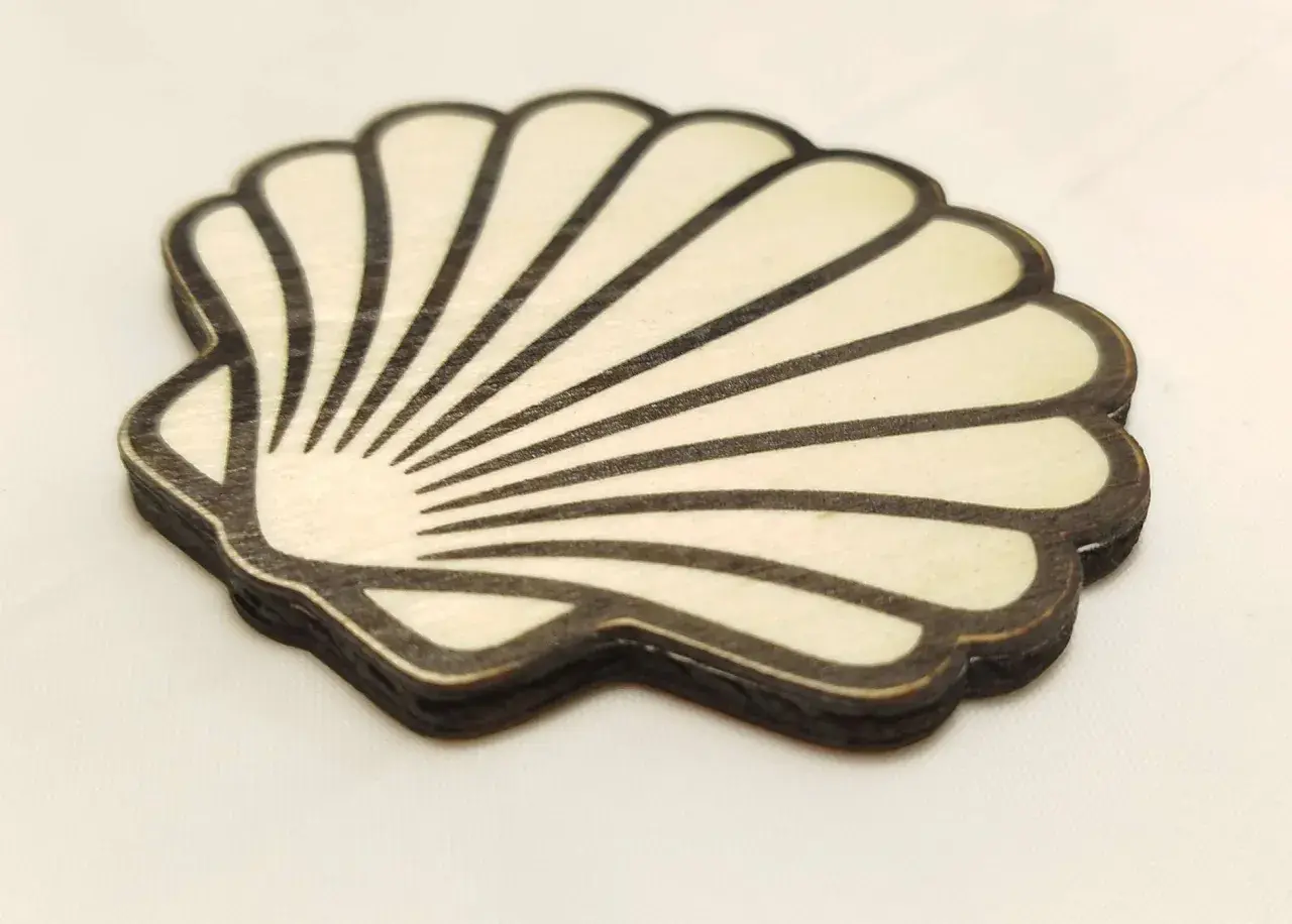 Coquille de bois stylisée, rappelant la coquille Compostelle, avec des lignes noires sur fond clair.