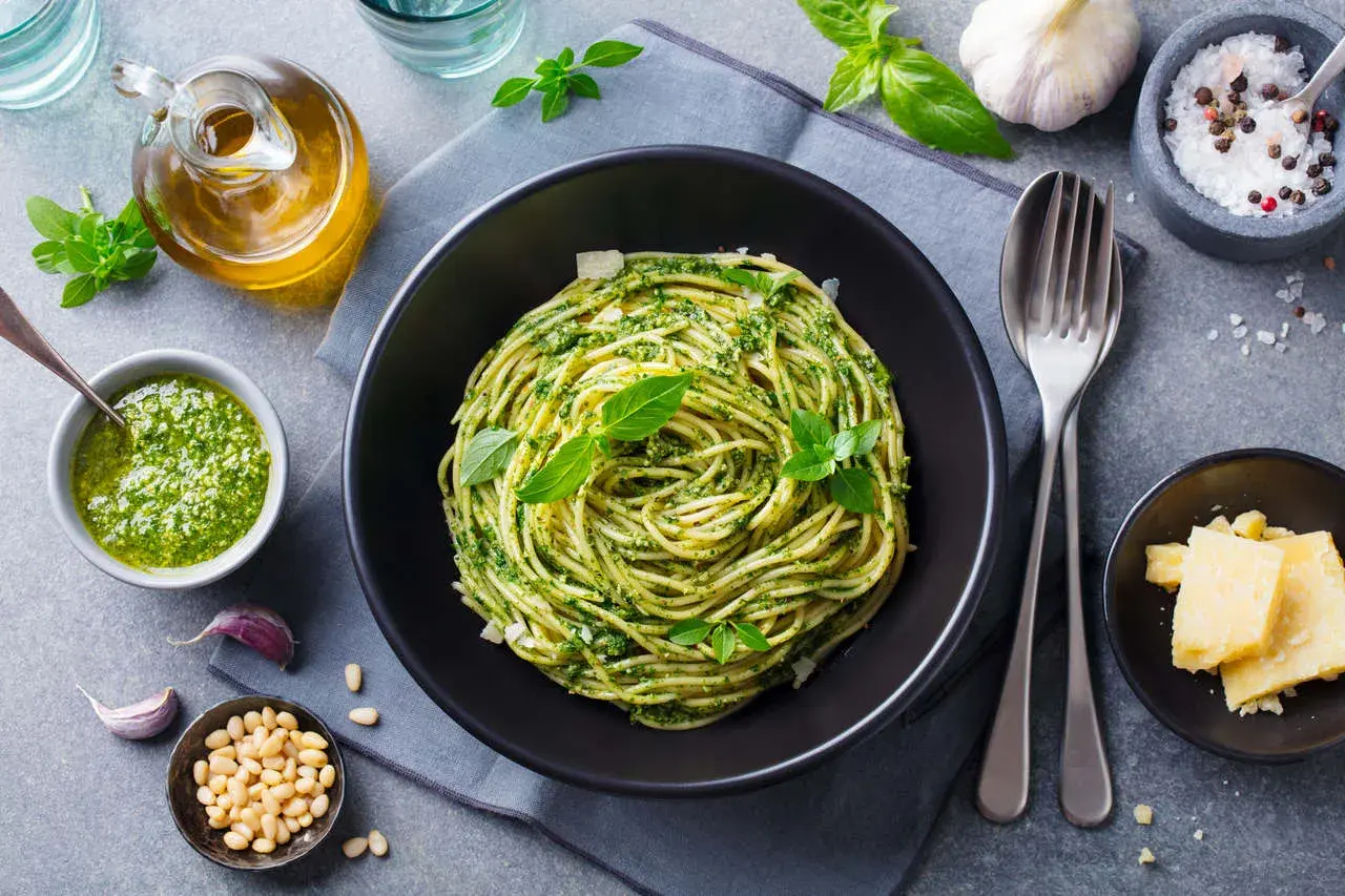 Pyszny obiad na niedzielę: spaghetti z pesto, świeżą bazylią, orzeszkami pinii i parmezanem. Idealny smak lata.