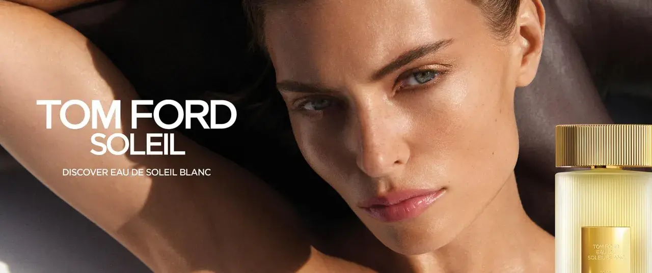 Kobieta z lśniącą skórą, obok flakonik perfum Tom Ford Soleil. Odkryj zapach Eau de Soleil Blanc.