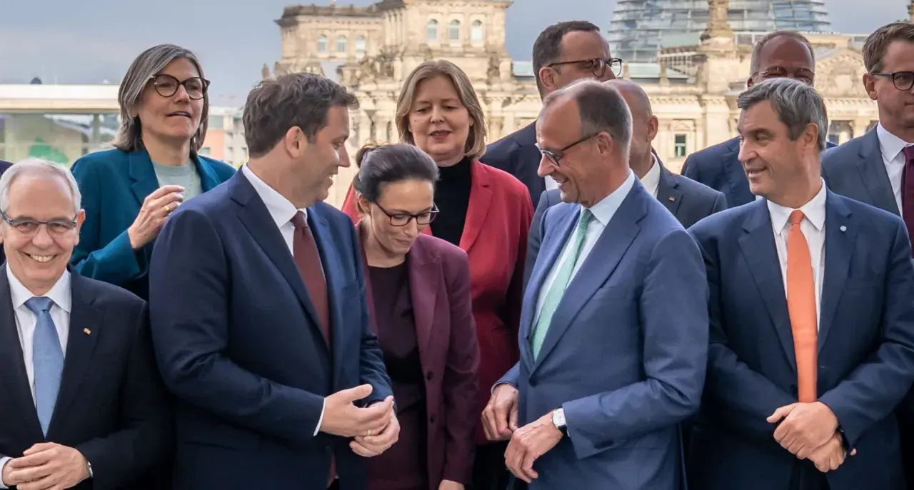 Politiker posieren vor dem Reichstag. Sie scheinen über die Bildung einer Koalition zu sprechen, was bedeutet, dass verschiedene Parteien zusammenarbeiten, um eine Regierung zu bilden.