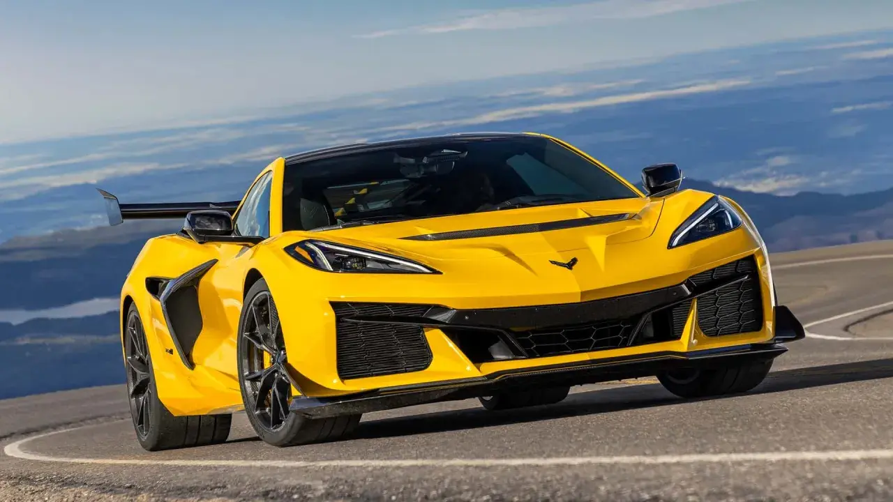 Żółty Chevrolet Corvette C7 ZR1 z dużym tylnym skrzydłem pędzi po górskiej drodze, gotowy na każde wyzwanie.