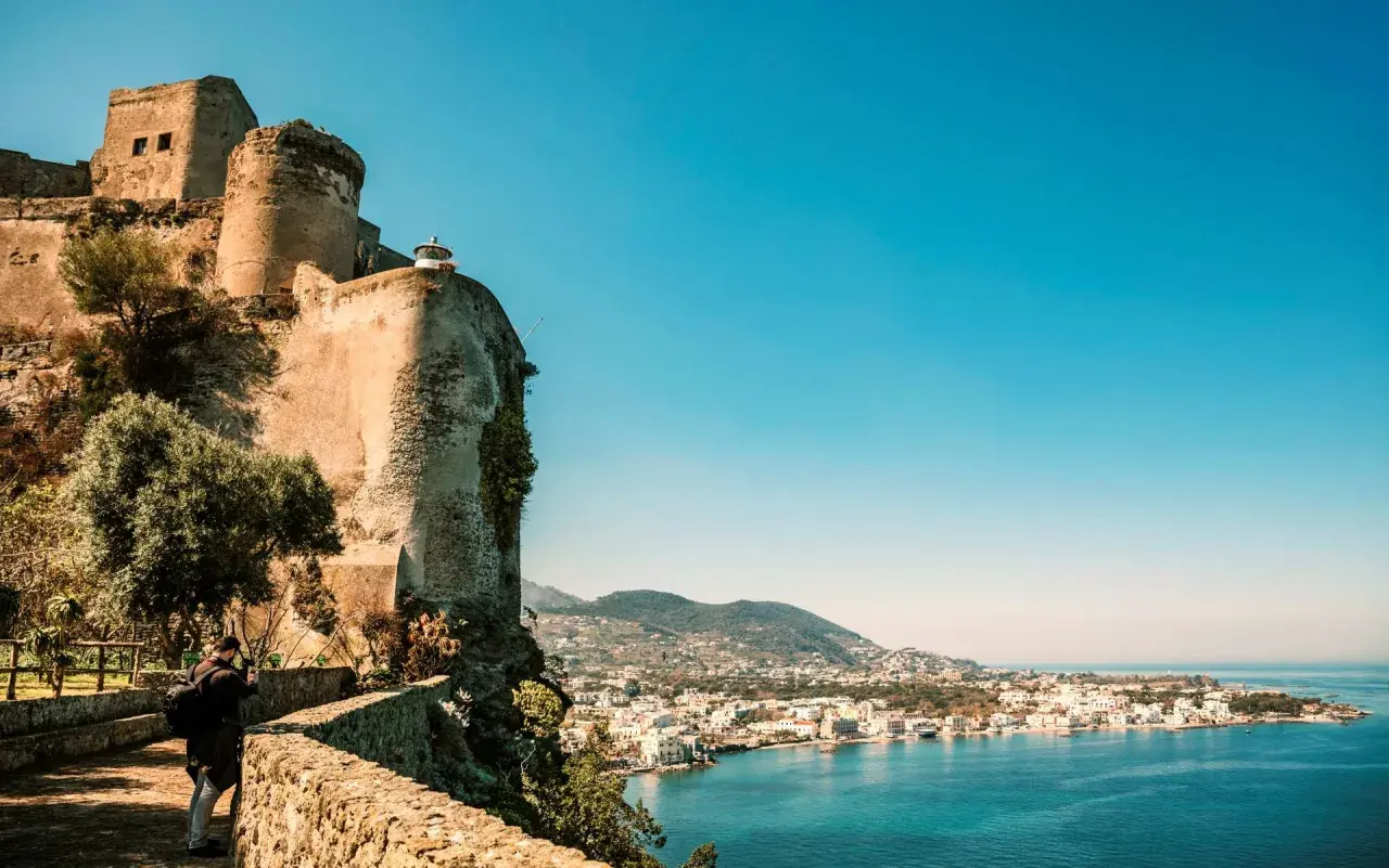 Antico castello a picco sul mare, con vista sulla costa di Ischia. Un fotografo cattura la bellezza del panorama, un ricordo di Ischia Castel Sant'Angelo.