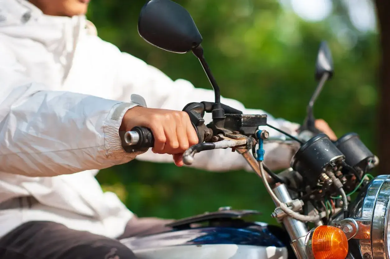 Mano sujetando el acelerador de una moto, con la llave del gas abierta, lista para la aventura.