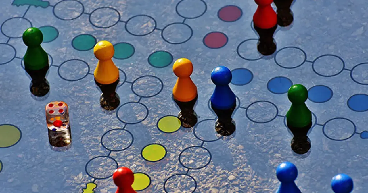 Kolorowe pionki i kostka do gry na planszy. Kto pierwszy dotrze do mety w tej emocjonującej grze słów?