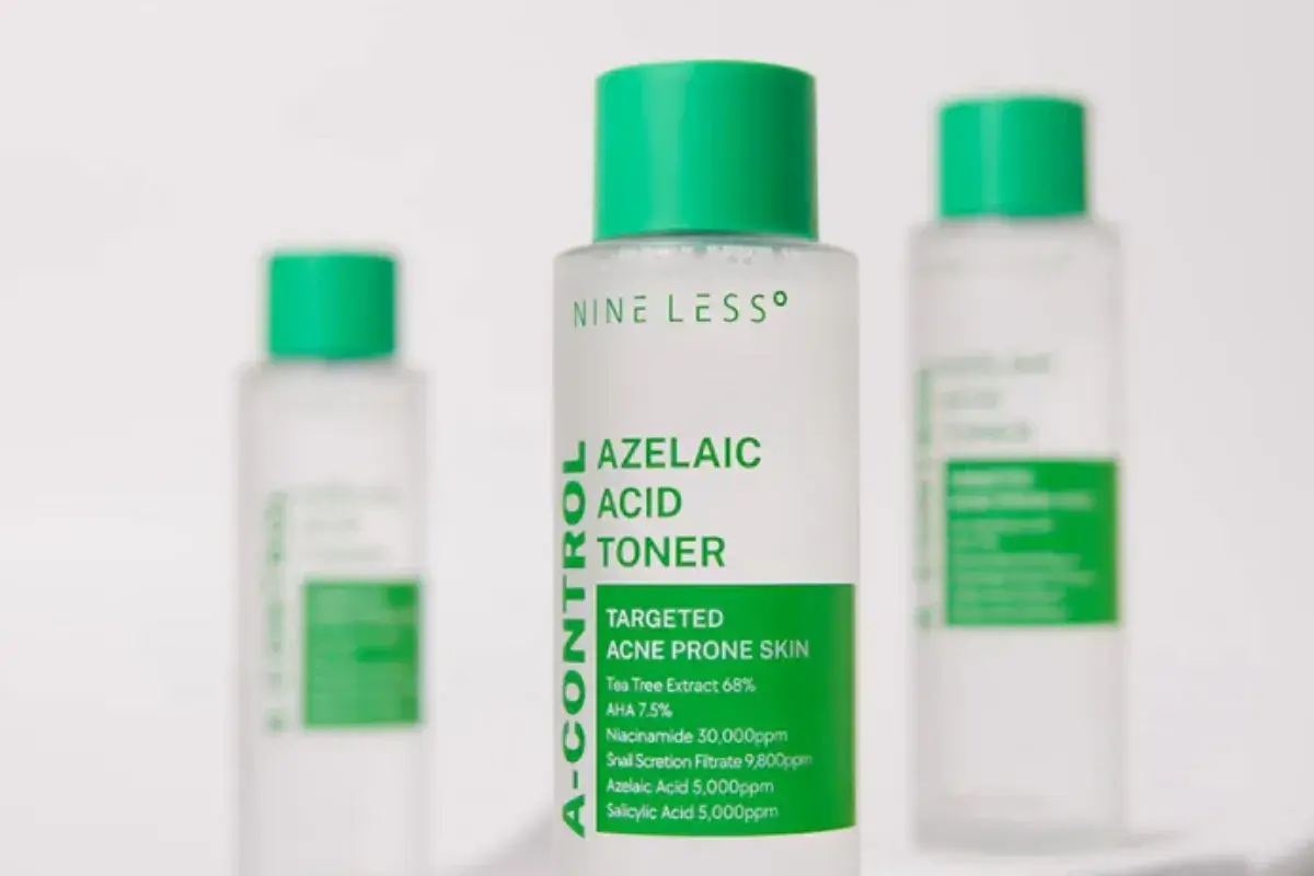 Tre flaskor med ansiktsvatten, varav en i fokus med texten "Azelaic Acid Toner". Perfekt för aknebenägen hud.