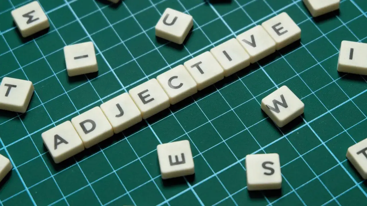 Tessere con lettere formano "ADJECTIVE". Alcune lettere sparse, come "S", suggeriscono la creazione di aggettivi con s.