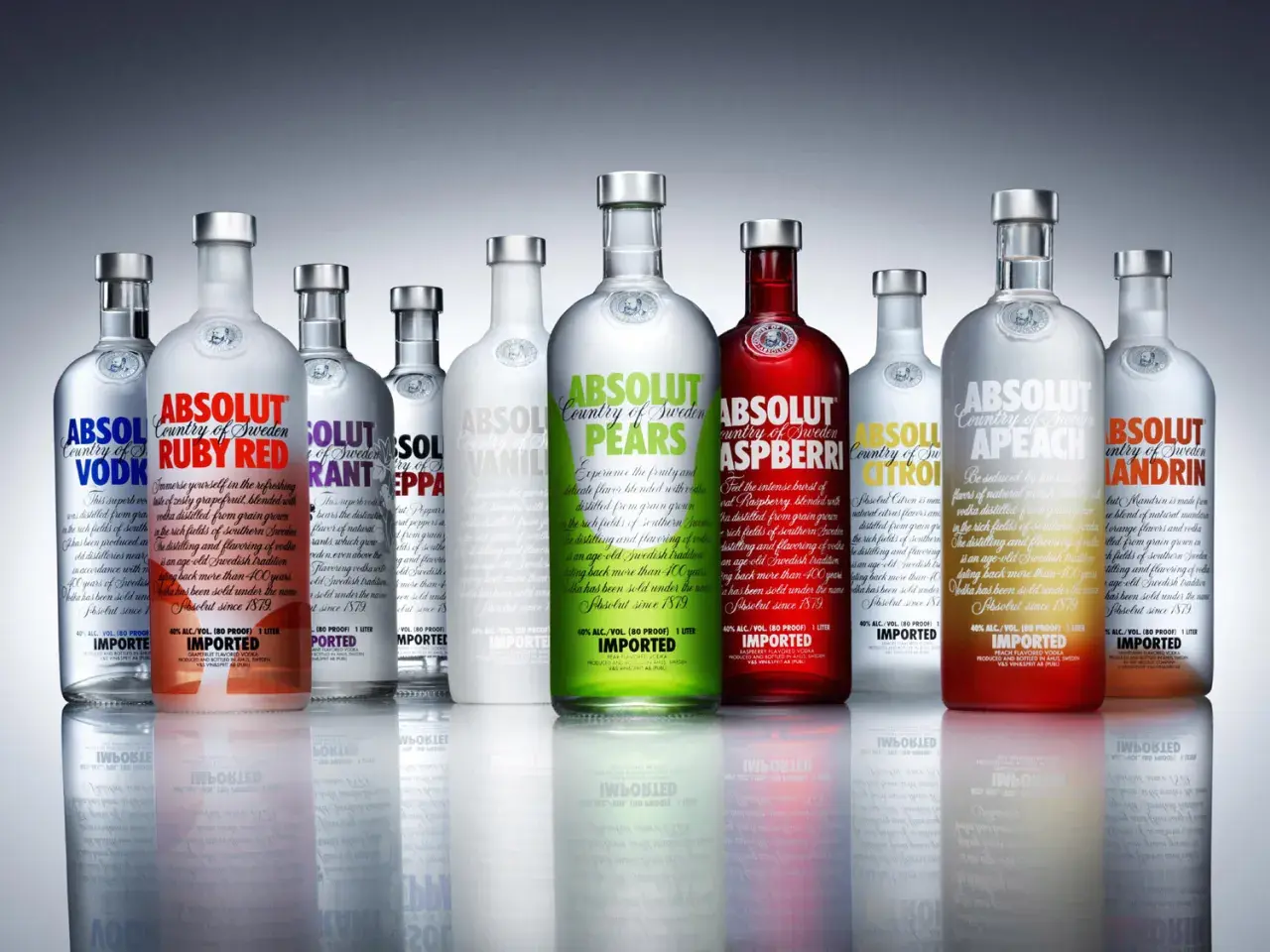 Rząd butelek wódki Absolut, w tym smaki Ruby Red, Pears, Raspberry, Citron, Apeach i Mandrin.