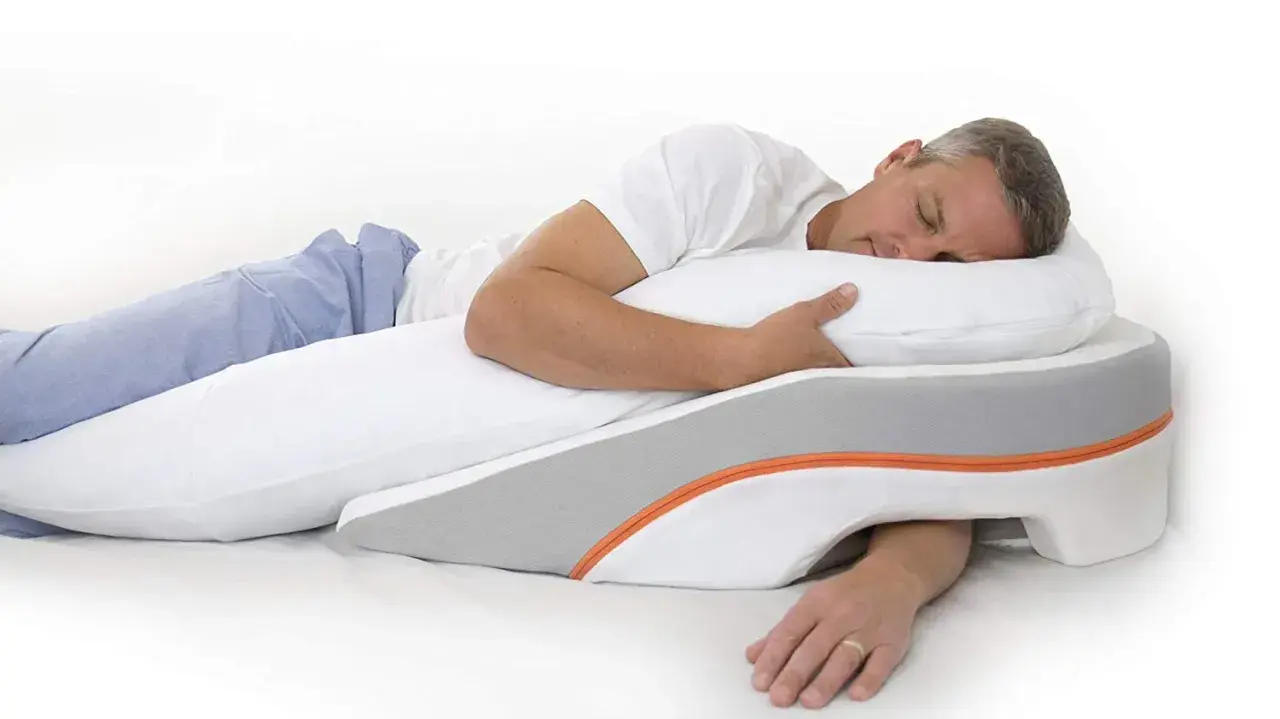 Man sleeping on his left side, using a wedge pillow designed to help with reflux.