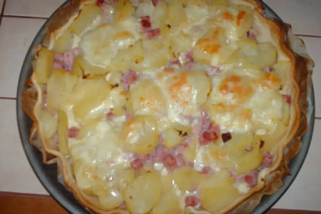 Tarte façon raclette, garnie de pommes de terre, lardons et fromage fondant. Un délice réconfortant !