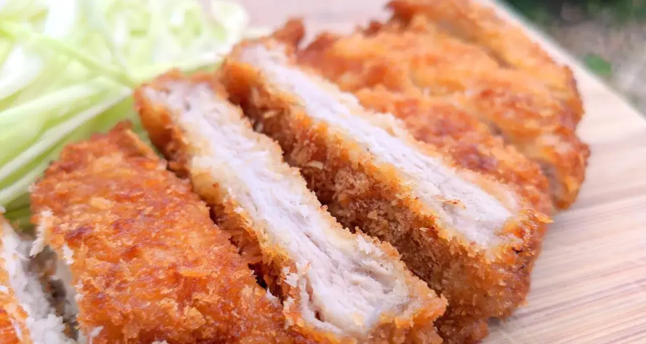Juicy, baked tonkatsu, sliced and served with shredded cabbage. A delicious and crispy meal.