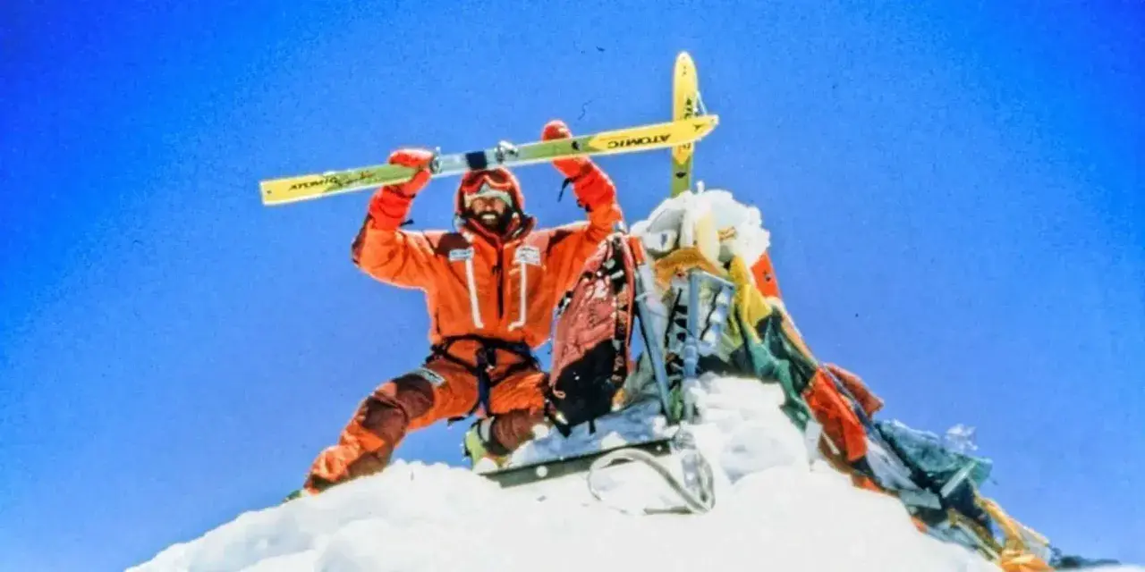 Hans Kammerlander, con esquís, celebra en la cima nevada.