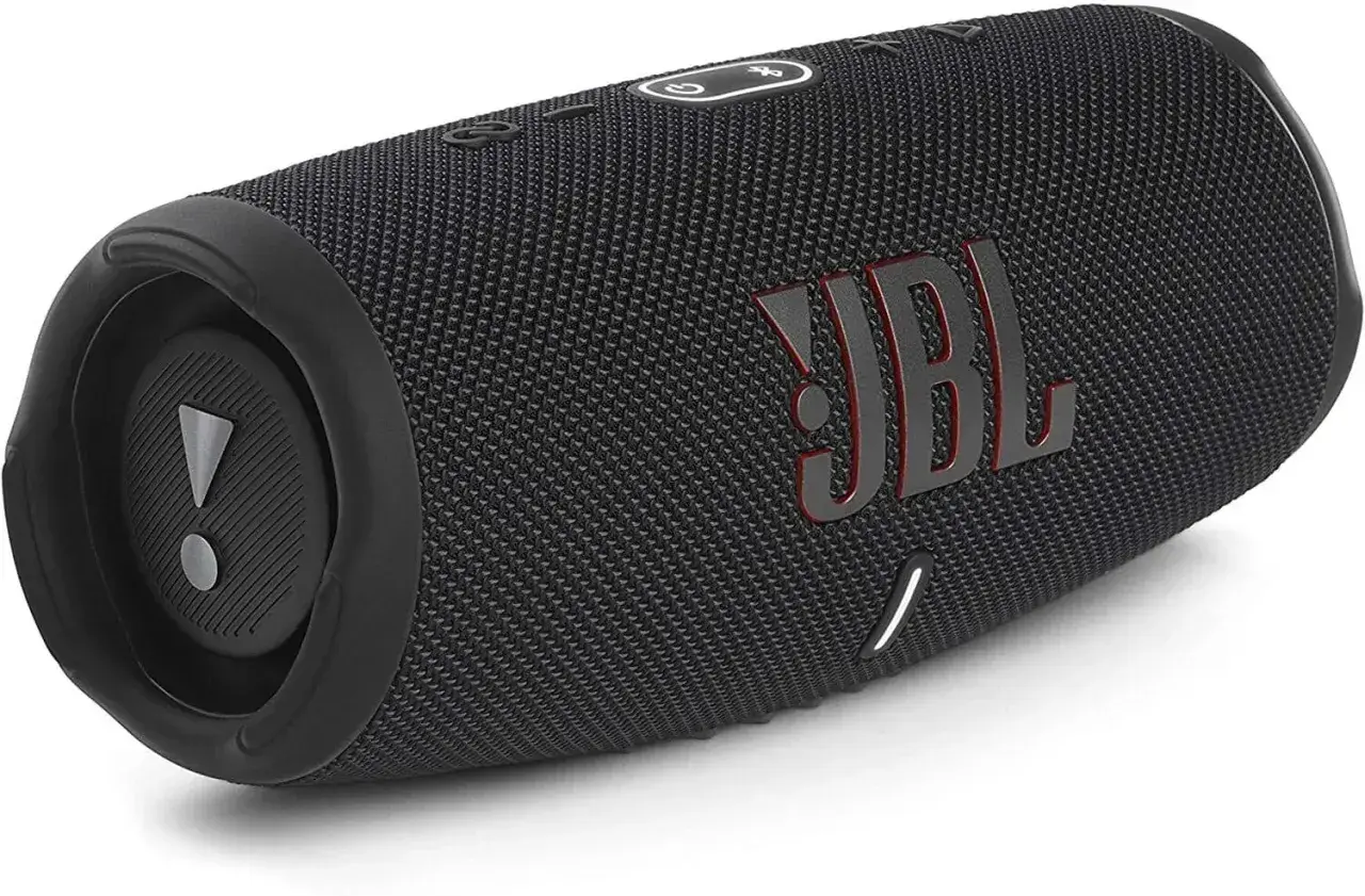 Czarny głośnik JBL z czerwonym logo. Dowiedz się, jak podłączyć słuchawki JBL z iPhone, by cieszyć się muzyką.