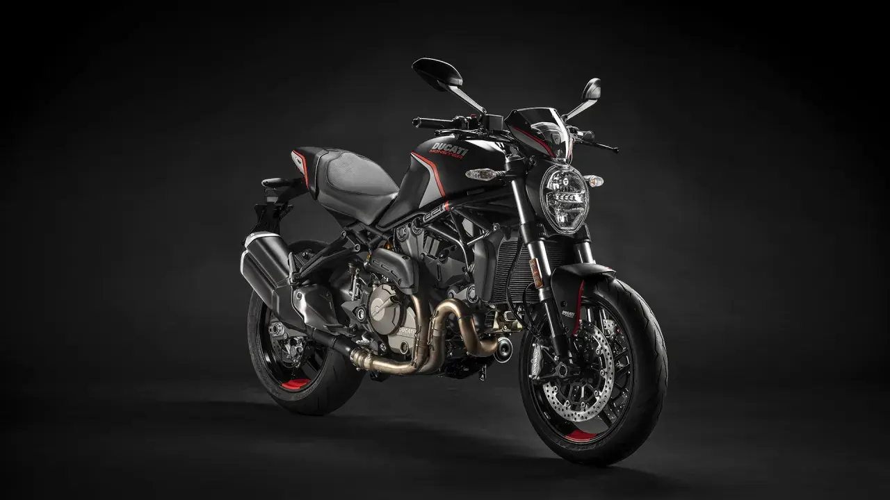 Czarny motocykl Ducati Monster na ciemnym tle.