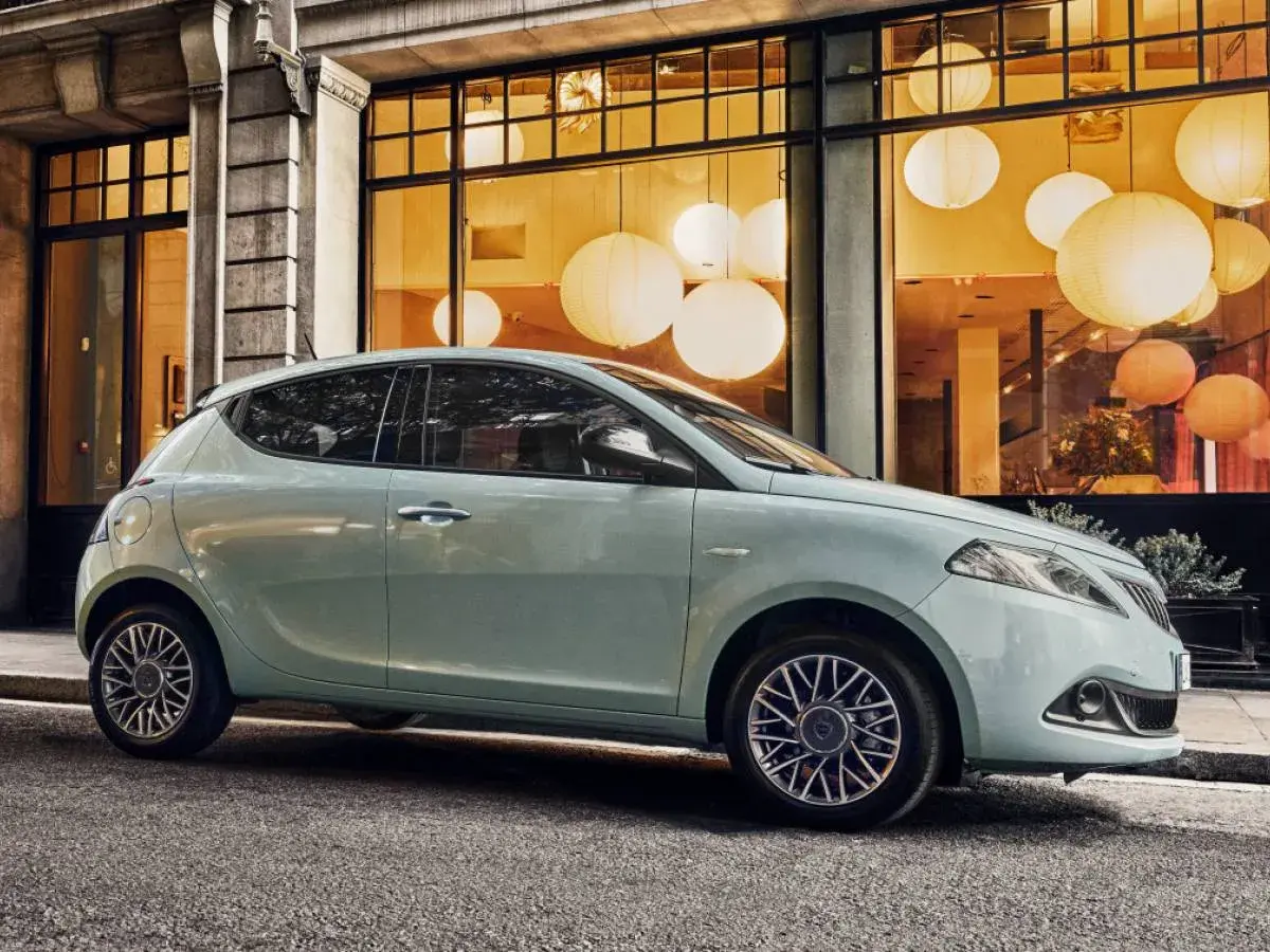 City car 5 posti azzurra parcheggiata davanti a una vetrina con lanterne luminose.
