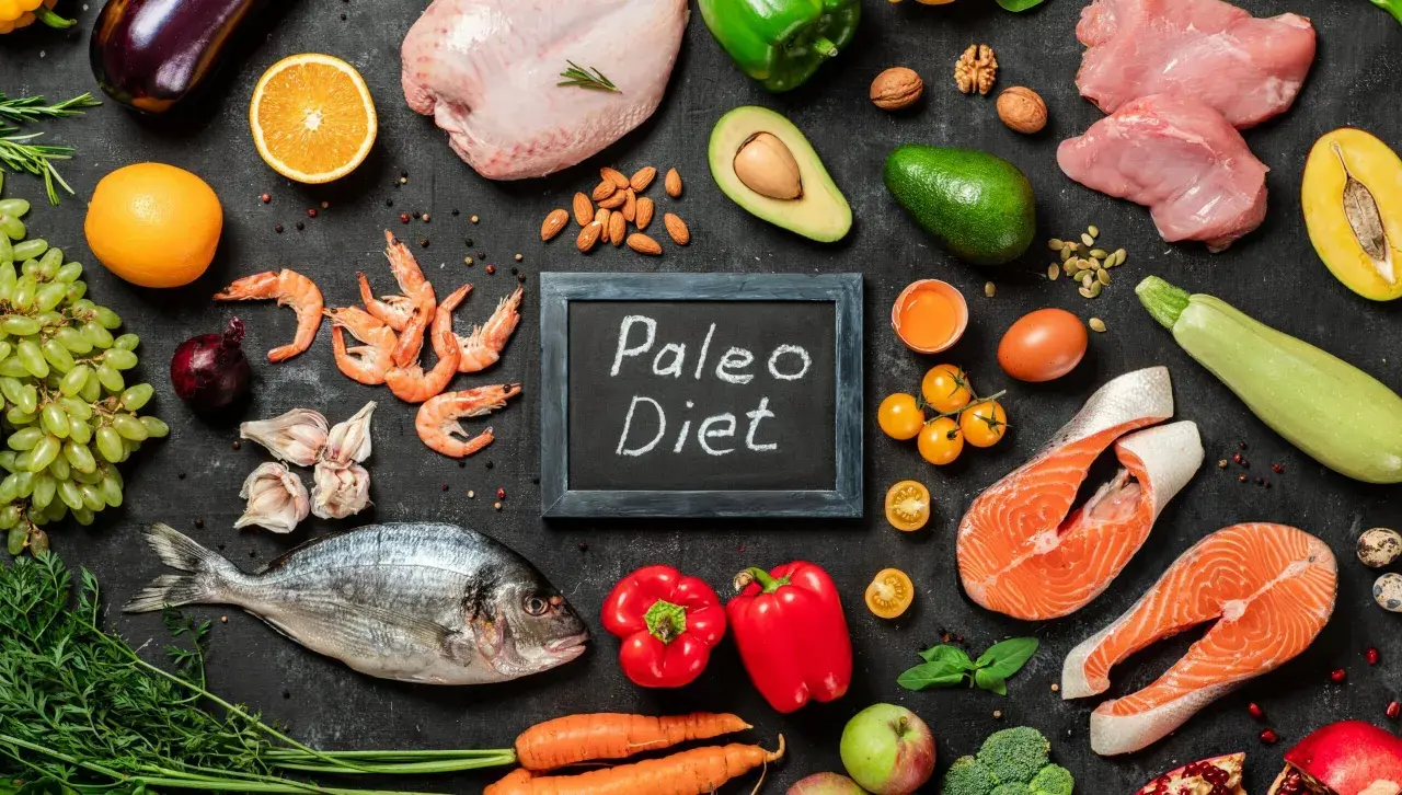 Ingredienti freschi per la dieta paleo: pesce, carne, verdura, frutta, uova e noci.