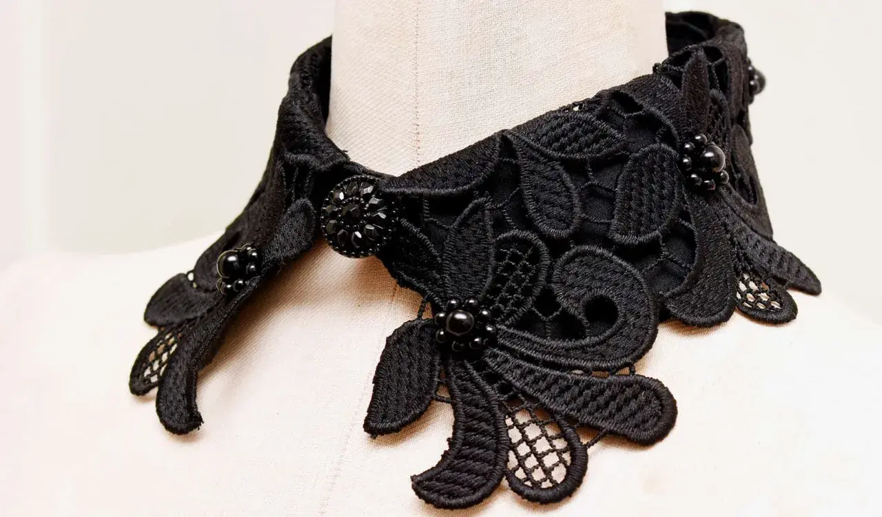 Intricate black lace collar with beaded embellishments, perfect for adding a touch of elegance. Learn how to make a lace collar with this detailed view.