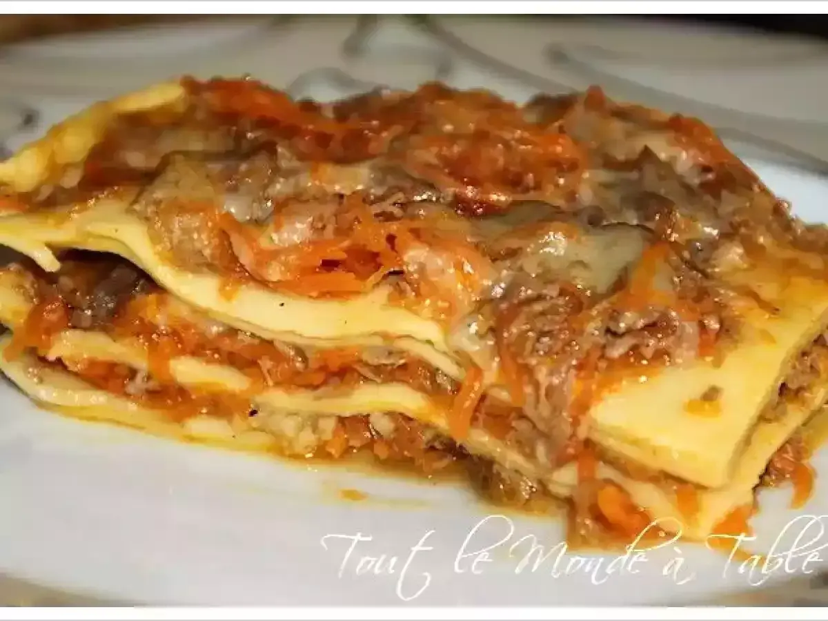 Une généreuse part de lasagne de canard, avec ses couches de pâtes, de viande effilochée et de sauce aux carottes, prête à être dégustée.