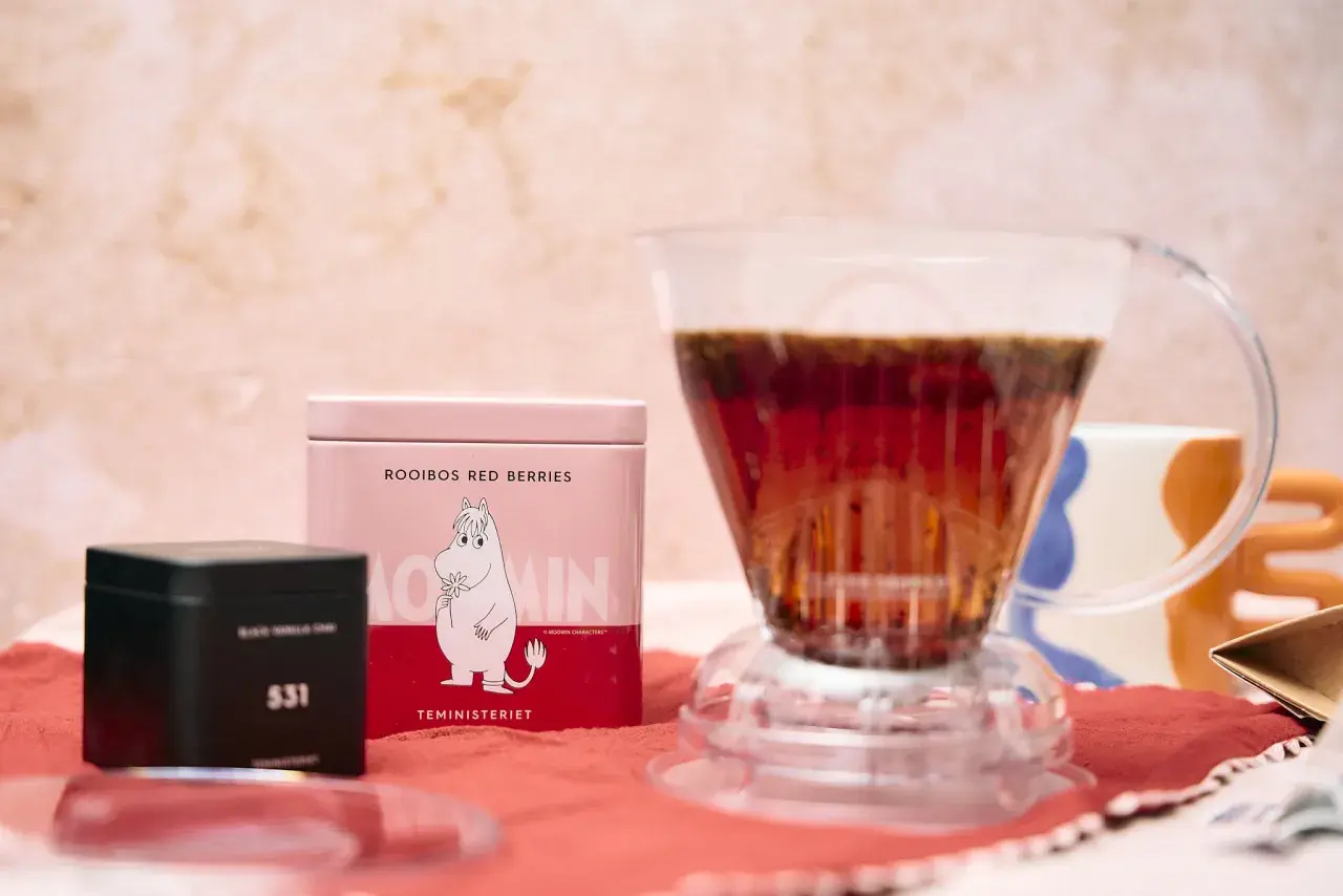 Rooibos z czerwonymi jagodami, przygotowywany do zaparzenia. Obok puszka z Muminkiem i czarna puszka z numerem 531. To nie herbata ze Sri Lanki, ale pyszny napar.