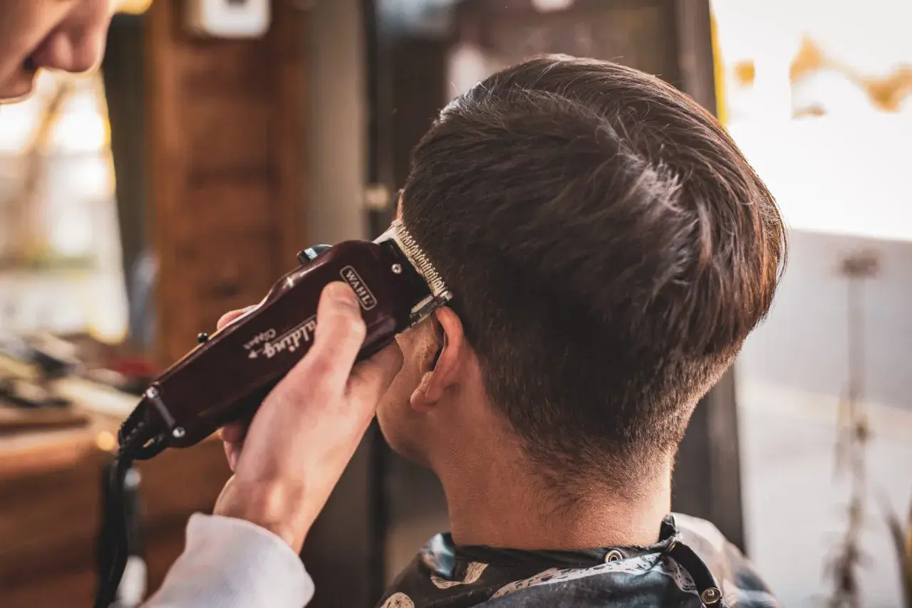 Un hombre se corta el pelo con una máquina Wahl. Es como soñar que te cortas el pelo, un cambio de look.