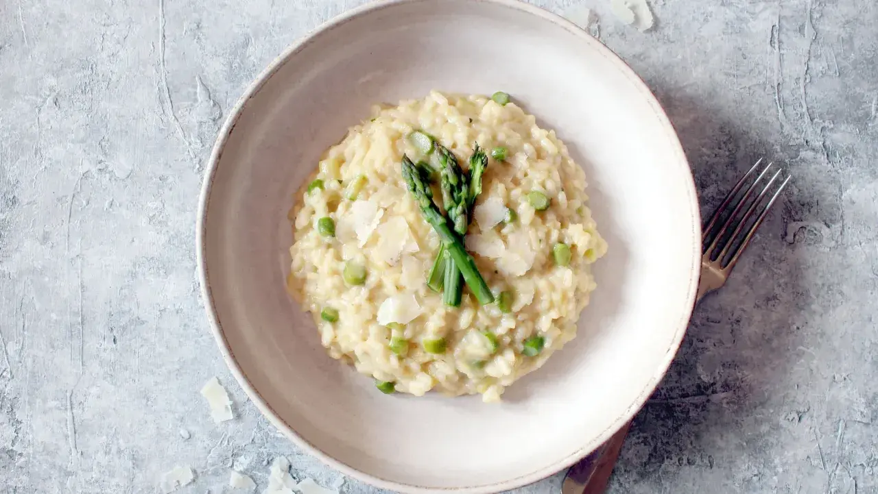 Cremiges Spargel-Erbsen-Risotto, garniert mit frischem Spargel und Parmesan. Ein köstliches Beispiel, was ist risotto.