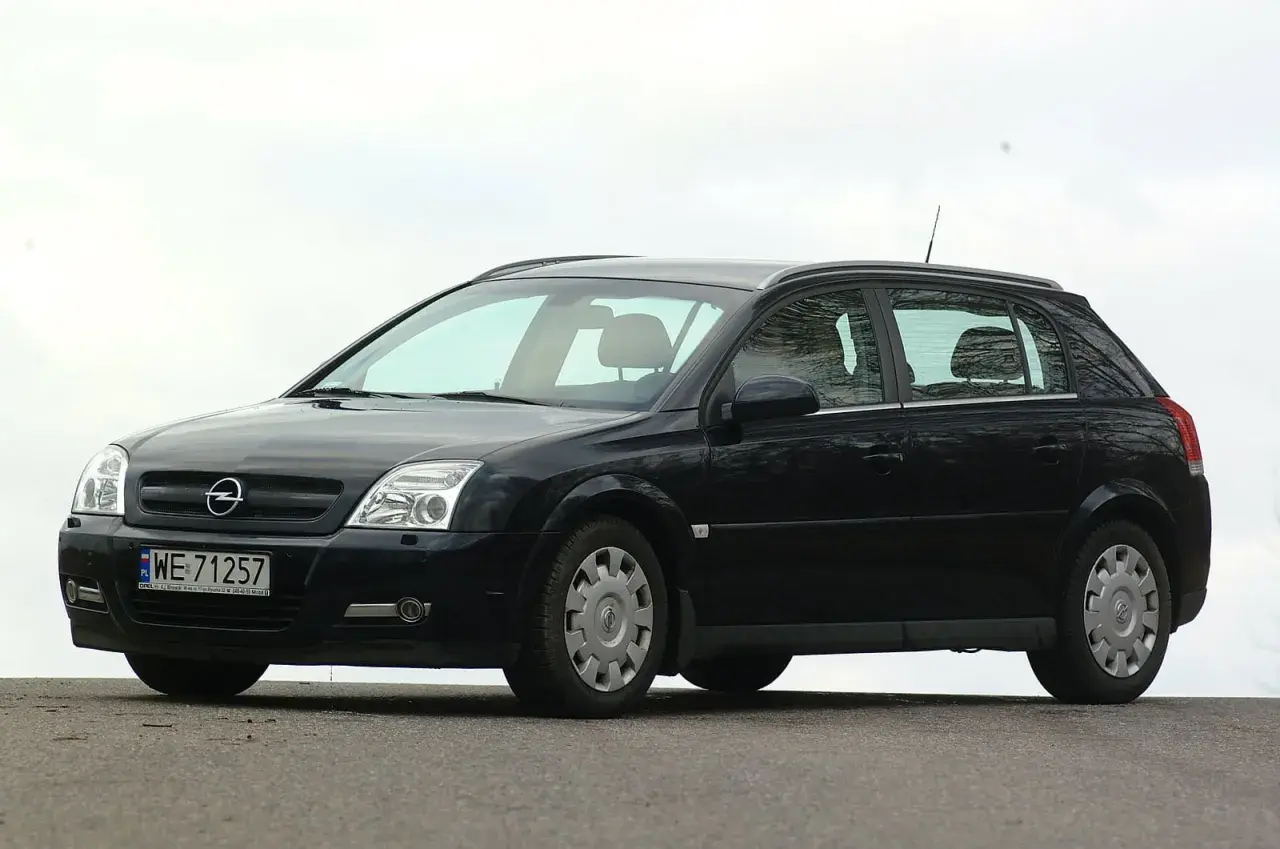Czarny Opel Signum z czystymi żarówkami reflektorów, zaparkowany na zewnątrz.