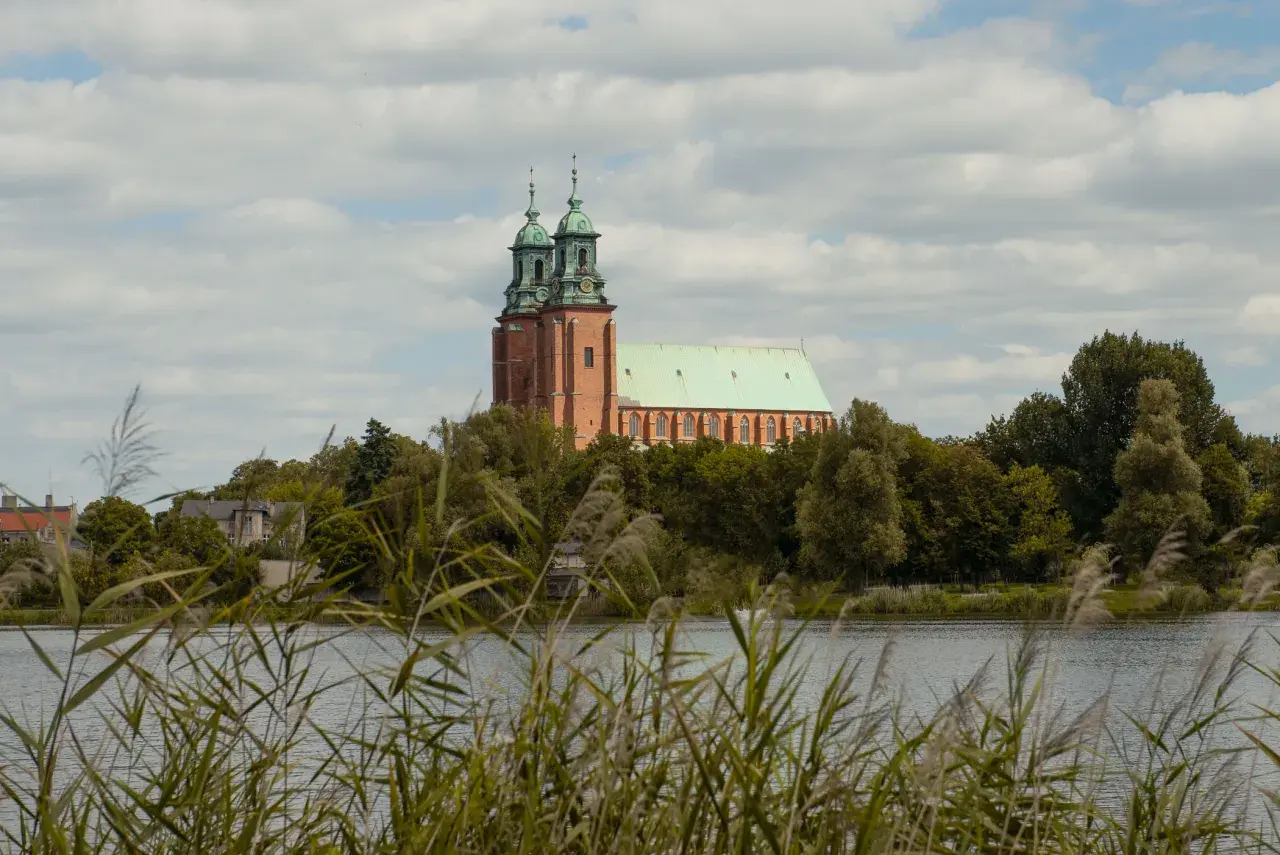 Majestatyczna katedra w Gnieźnie, jedna z głównych atrakcji miasta, góruje nad jeziorem.