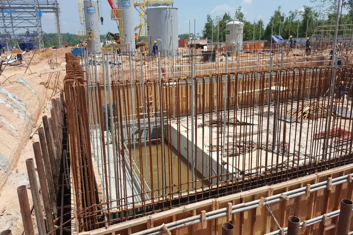 Budowa obiektu przemysłowego, widoczny szalunek i zbrojenie, które stanowią koszt fundamentów.