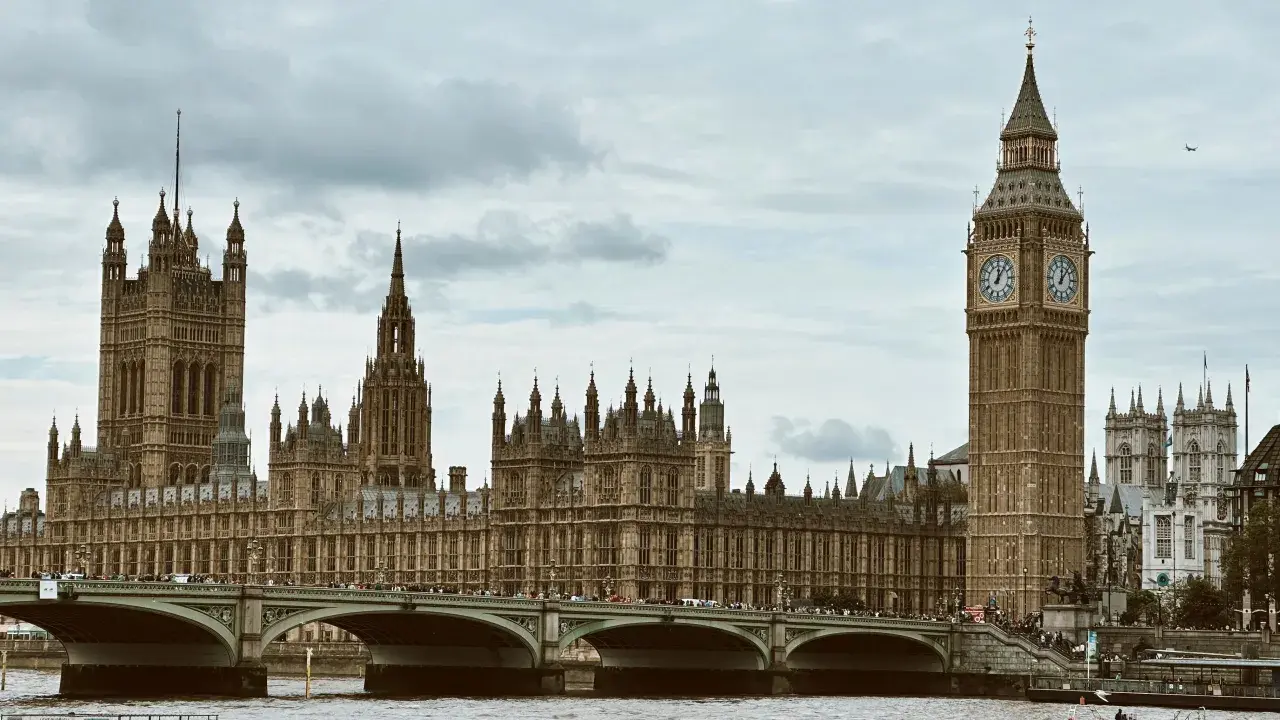 Pałac Westminsterski i Big Ben to ikony, które warto zobaczyć w Londynie. Most Westminster Bridge z tłumem turystów.