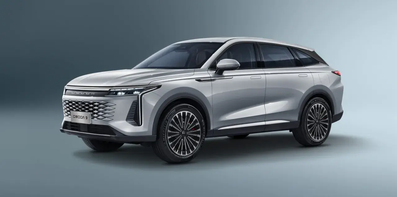 Srebrny SUV OMODA 9 z eleganckim grillem i nowoczesnymi światłami.