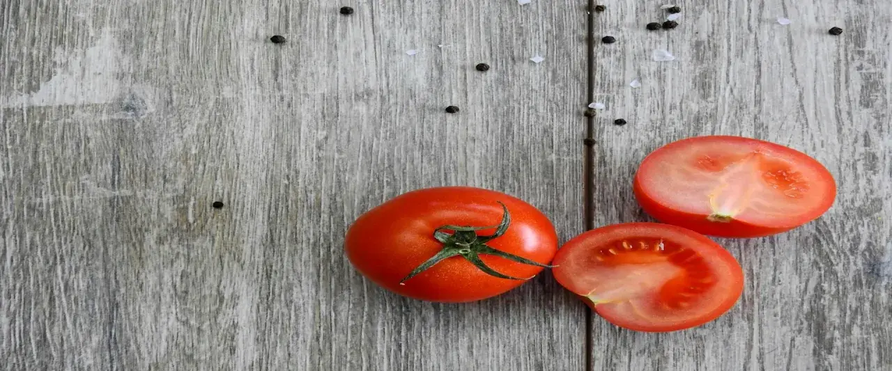Frische Tomaten, reich an Lycopin, liegen auf rustikalem Holz. Die Lycopin-Wirkung ist bekannt für ihre antioxidativen Eigenschaften.