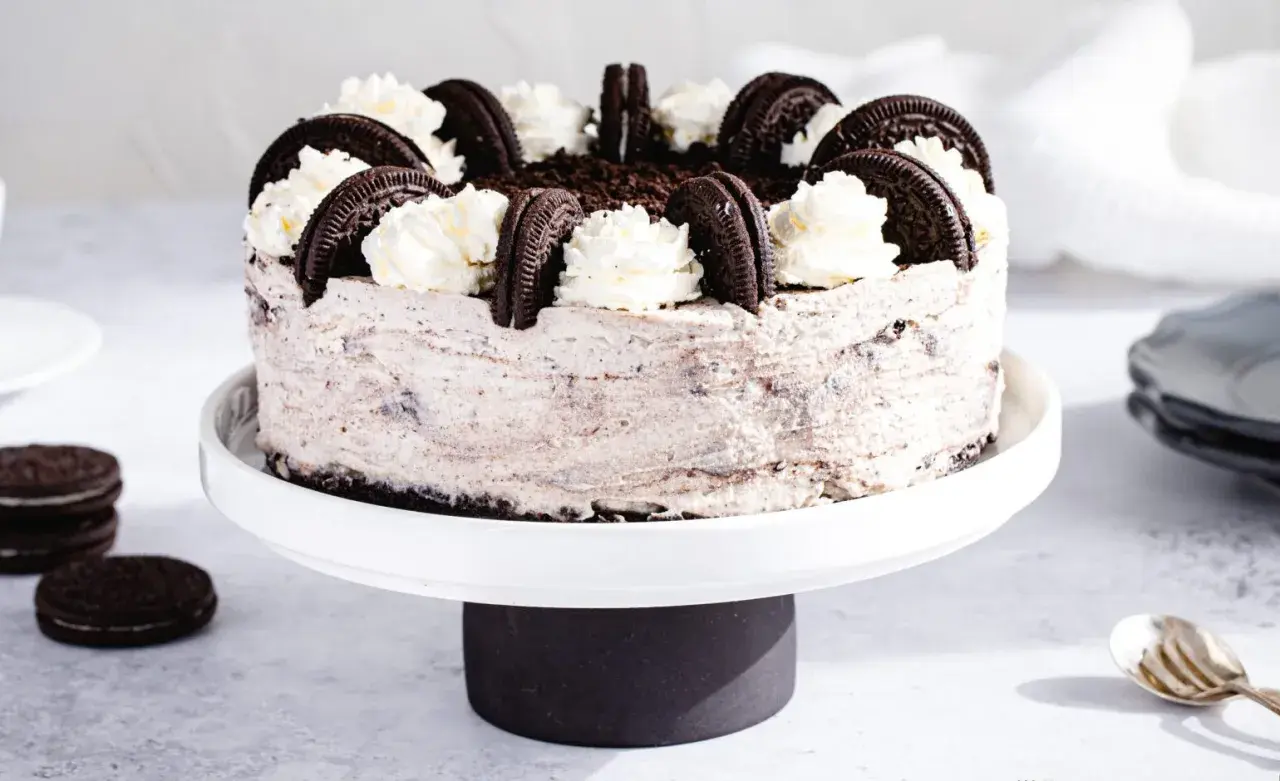 Wyjątkowe ciasto Oreo, udekorowane bitą śmietaną i ciasteczkami, kusi swoim wyglądem.