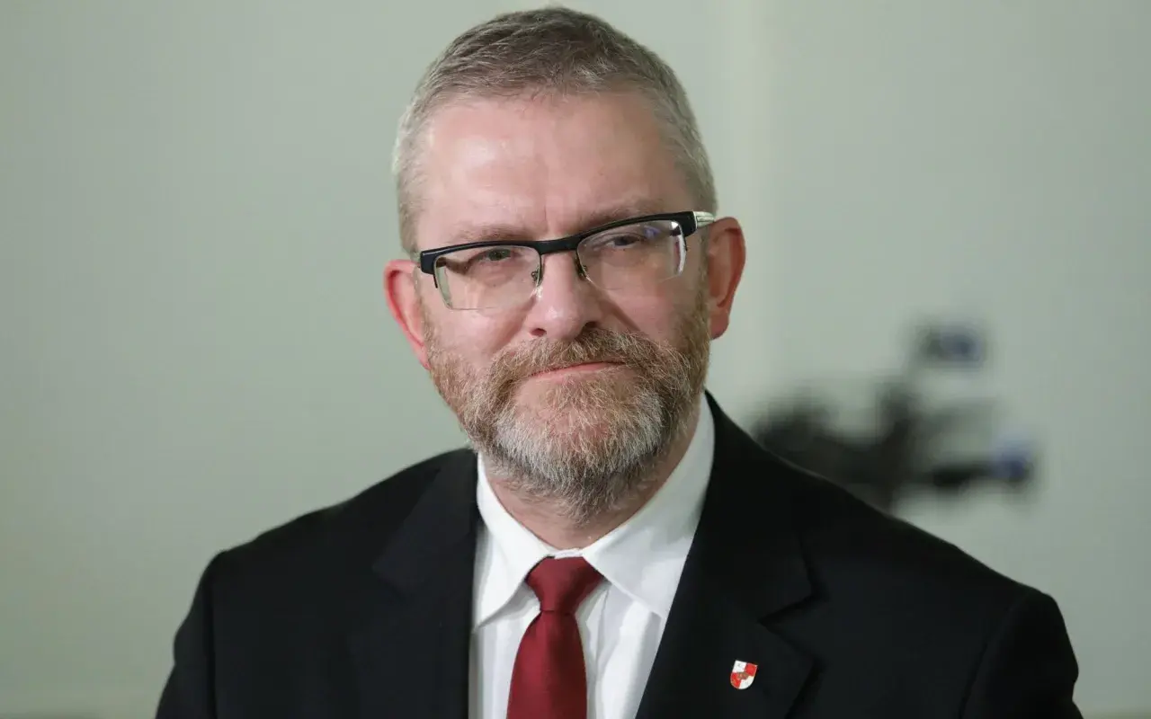 Grzegorz Braun w garniturze i krawacie, z okularami i brodą. Czy zostanie wykluczony z klubu za kontrowersyjne wypowiedzi o Izraelu?