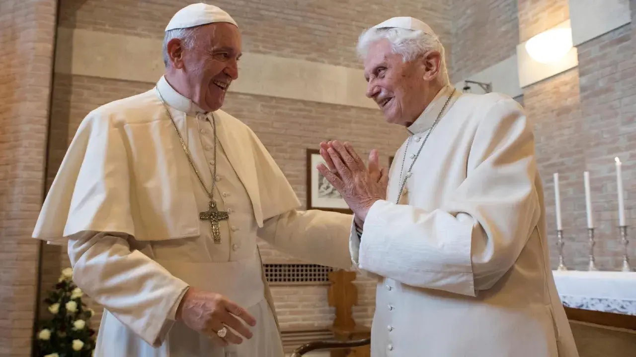 Zwei Päpste, Franziskus und Benedikt XVI., lachen sich an. Ihre Namen sind in der Geschichte des Papsttums unvergessen.