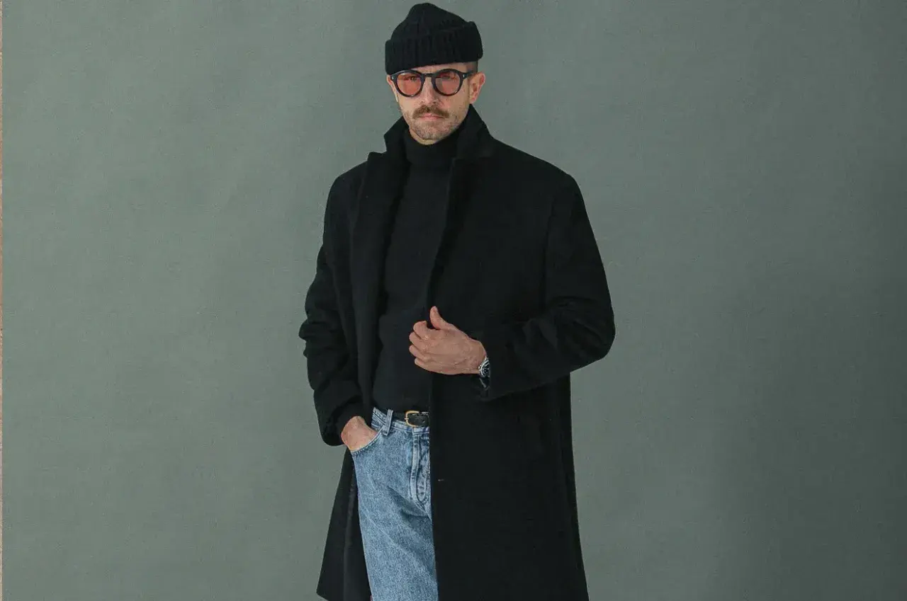 Un homme porte un manteau noir, un pull à col roulé, un bonnet et des lunettes. Faut-il prendre une taille au-dessus pour un manteau ?