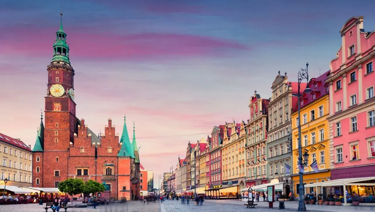 Rynek we Wrocławiu z Ratuszem i kolorowymi kamienicami o zachodzie słońca.