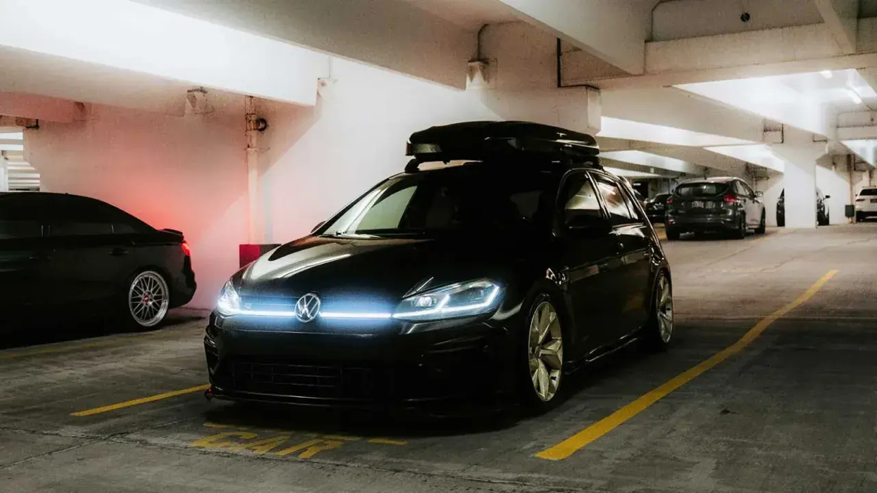 Svart VW Golf med takbox, redo för äventyr. Undrar hur mycket bensin en bil som denna drar?