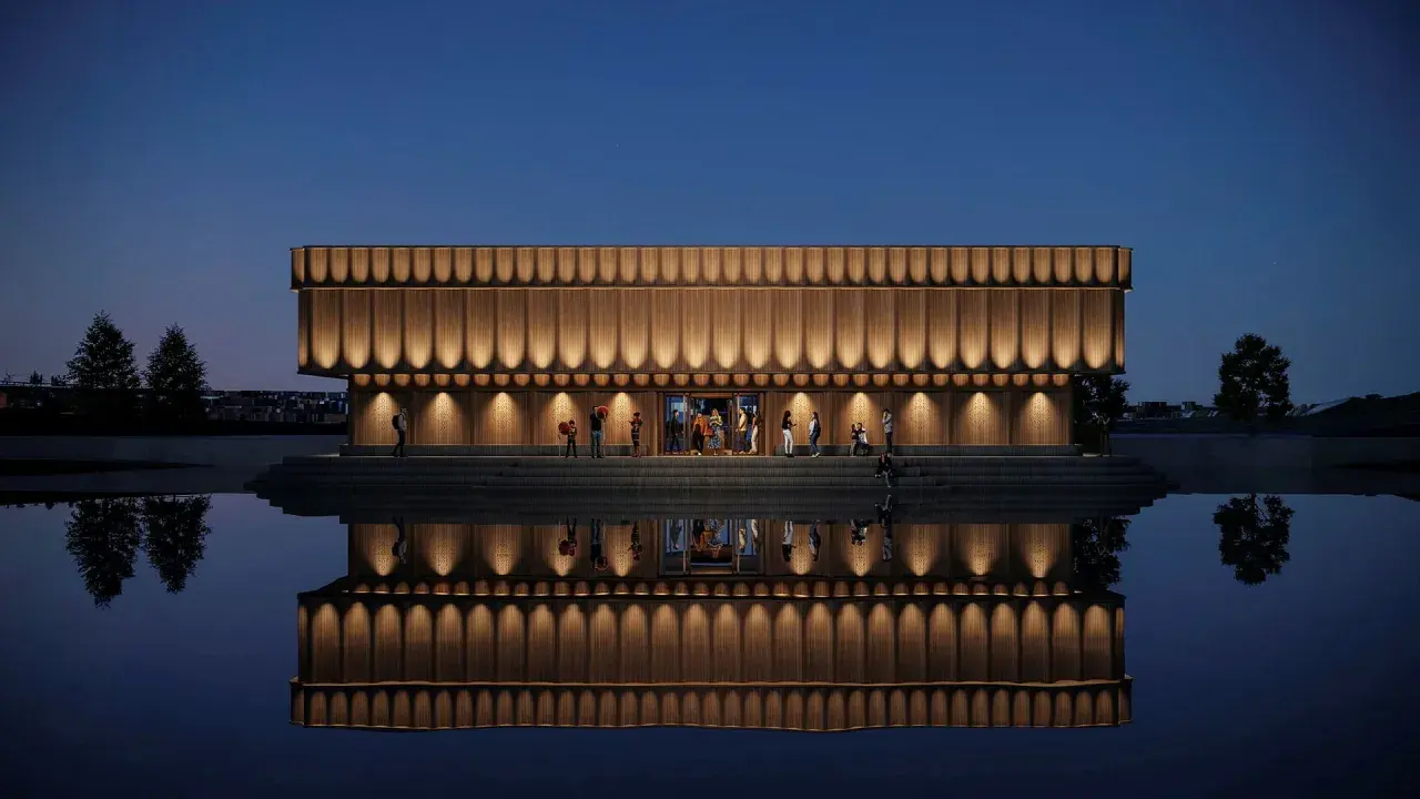 Elegant musik museum med träfasad och upplysta detaljer speglar sig i lugnt vatten.