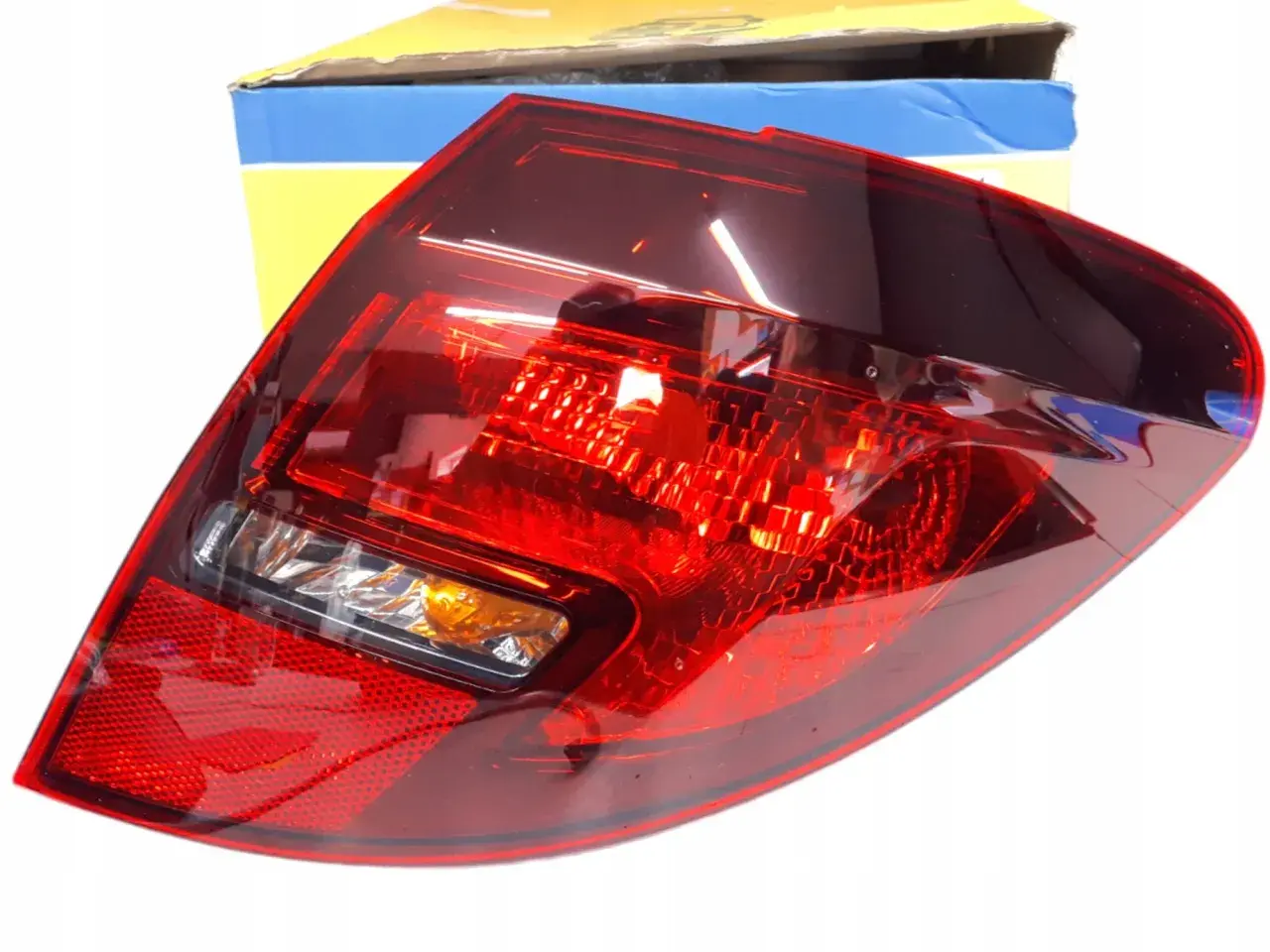 Tylna lampa zespolona do Opel Meriva B. Czerwona, z pomarańczowym kierunkowskazem. W zestawie z pudełkiem.