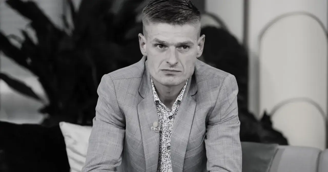 Tomasz Komenda, mimo młodego wieku, ma za sobą trudne doświadczenia. Na zdjęciu w garniturze i wzorzystej koszuli.