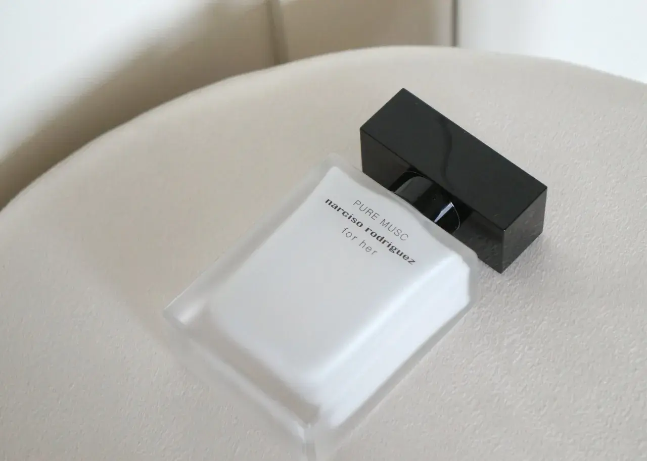 Elegancka butelka perfum Narciso Rodriguez Pure Musc for her, z czarną nakrętką, na jasnym tle.