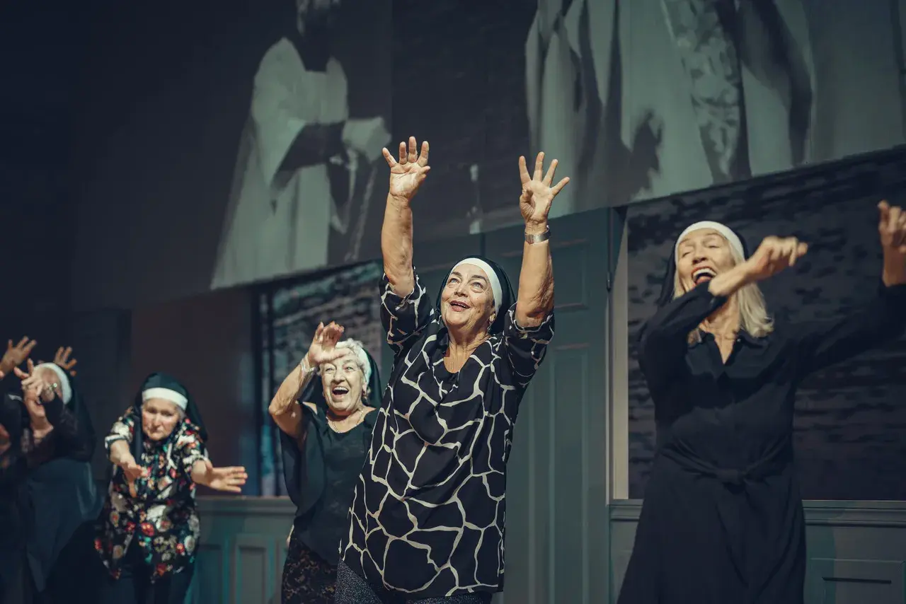 Radosne seniorki w habicie tańczą na scenie. Sprawdź repertuar Teatru Łaźnia Nowa!