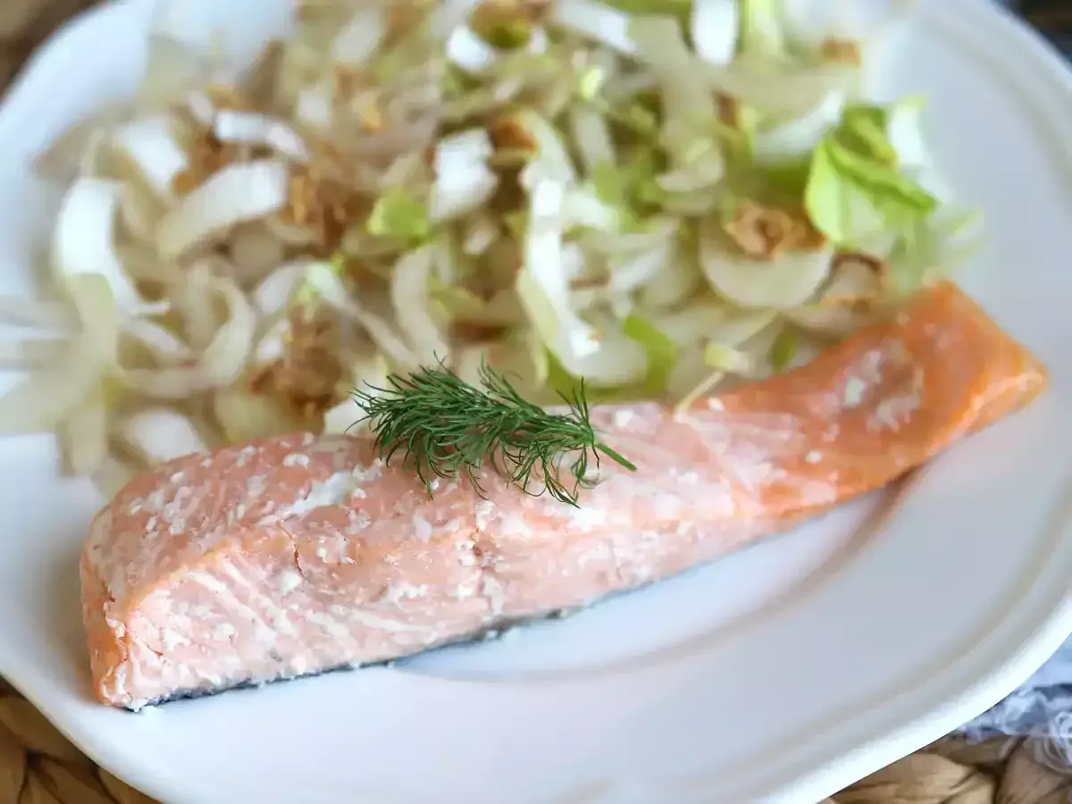 Un délicieux pavé de saumon rose, garni d'aneth frais, servi avec une salade croquante de fenouil et d'oignons.