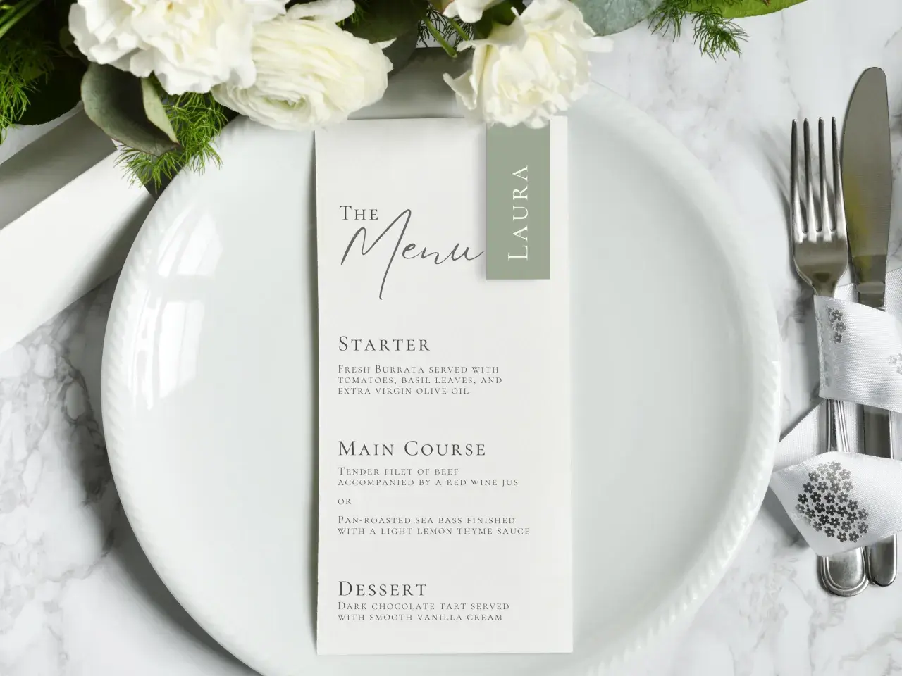 Menu mariage élégant avec des fleurs blanches. La formulation du menu détaille les plats : entrée, plat principal (filet de bœuf ou bar rôti) et dessert.