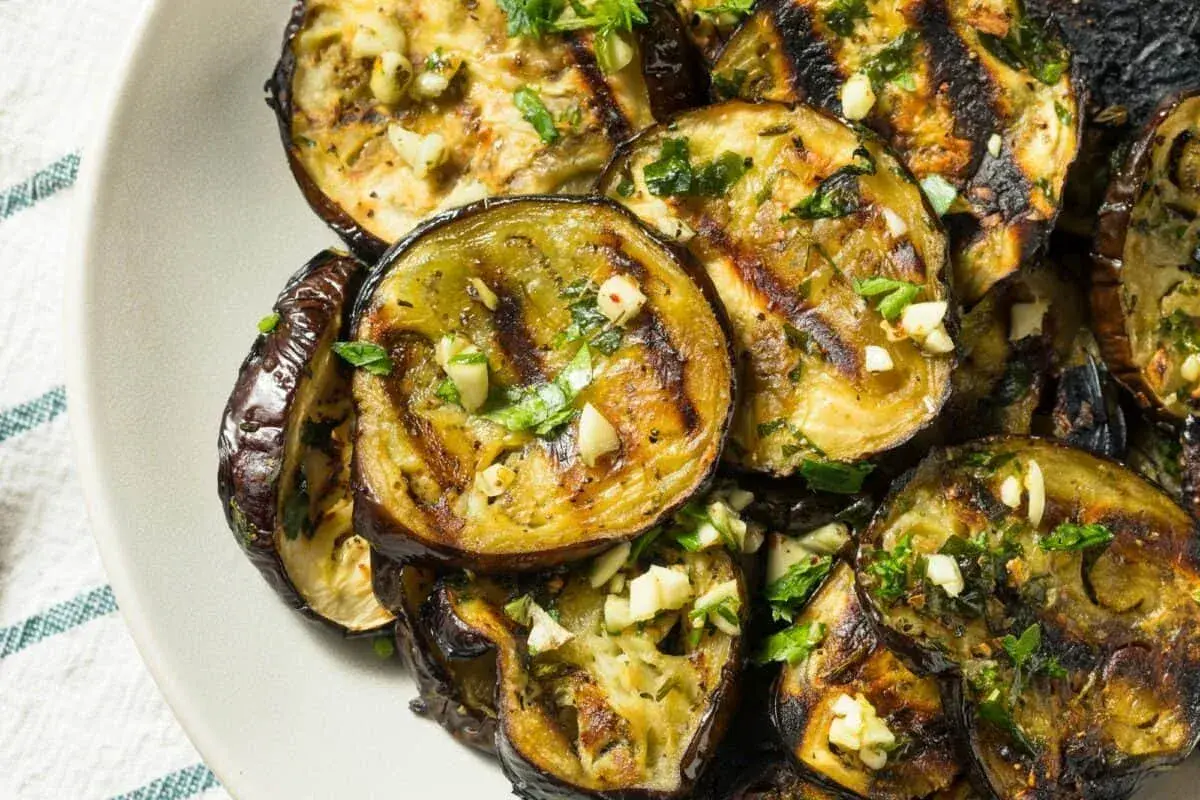 Aubergines grillées au four, garnies d'ail et de persil frais. Une recette simple et savoureuse pour sublimer ce légume.