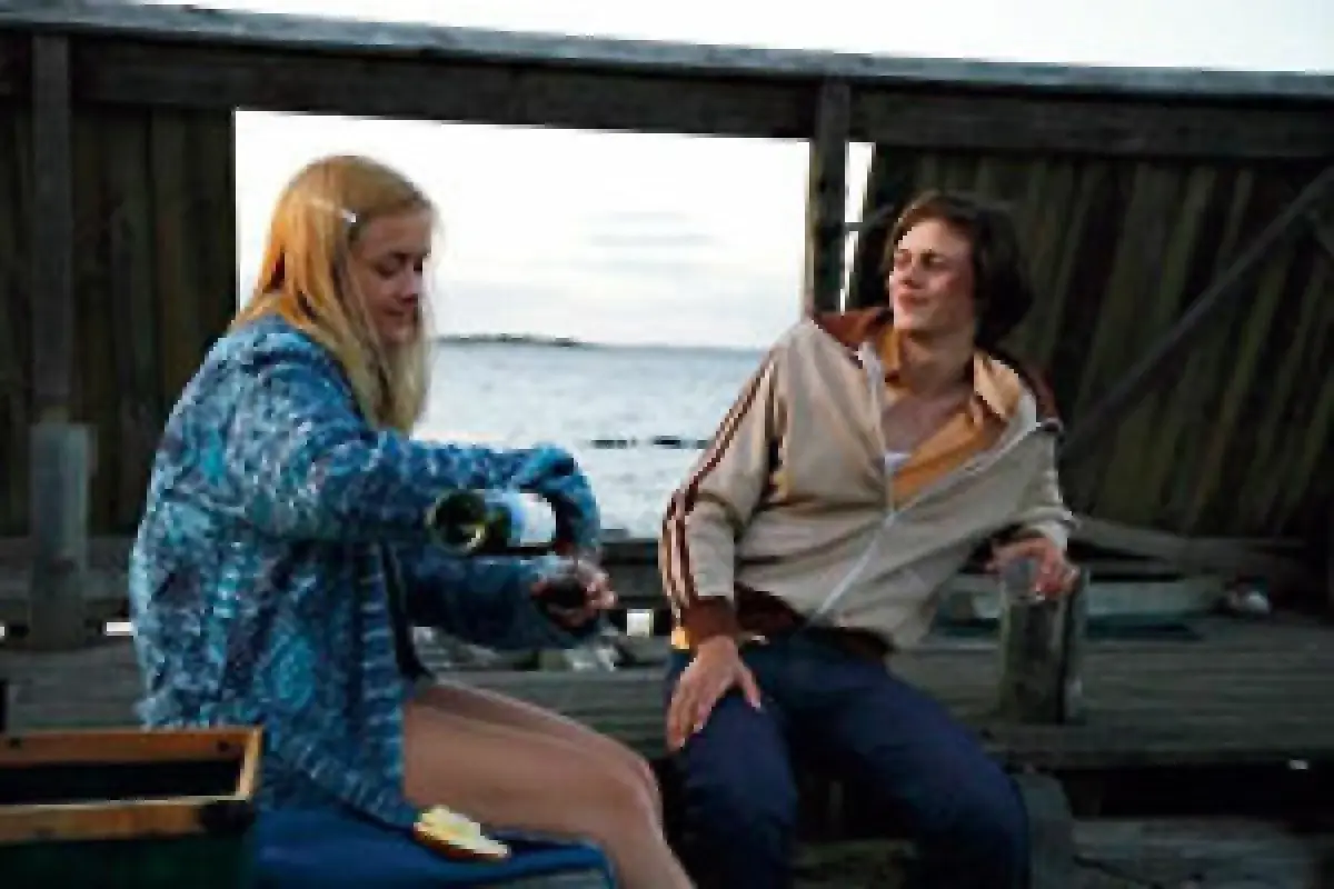 Två unga personer på en brygga, en häller upp vin. En scen som kunde vara från svenska filmer 2010-talet.