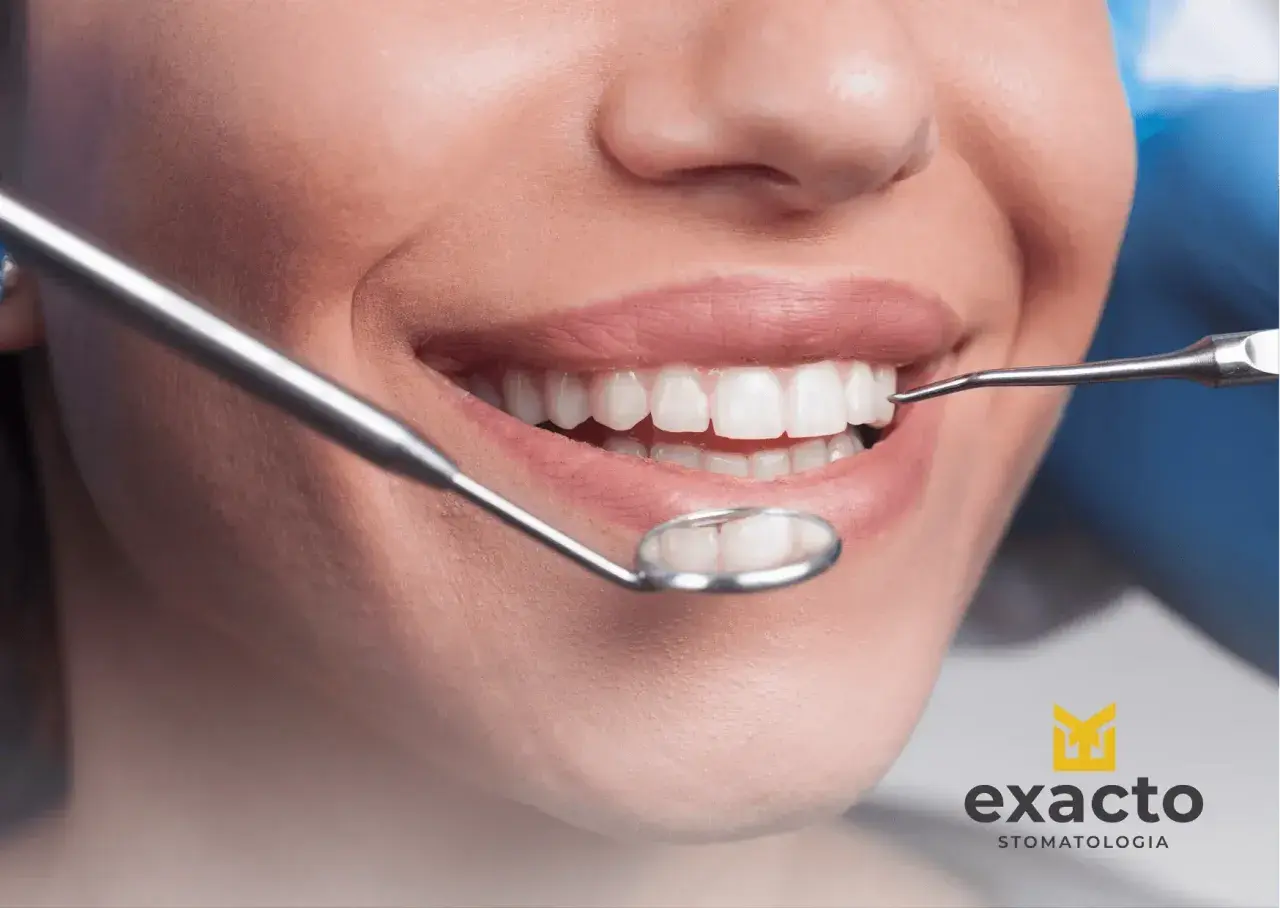 Uśmiechnięta pacjentka podczas wizyty w Exacto Stomatologia. Dentysta bada jej zdrowe zęby.