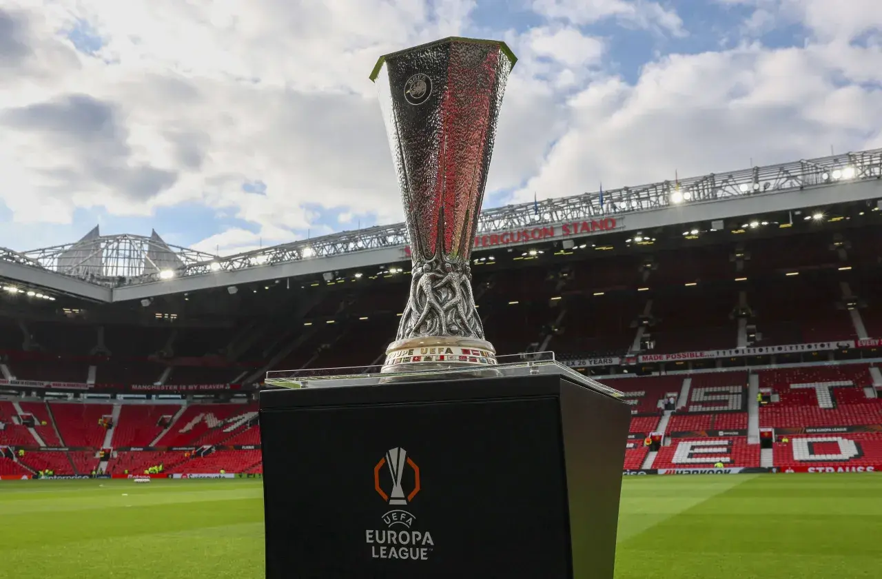 Trofeum Ligi Europy na tle stadionu Old Trafford. Marzenie o tym, by zdobyć ten puchar, jest bliskie spełnienia dla wielu drużyn.